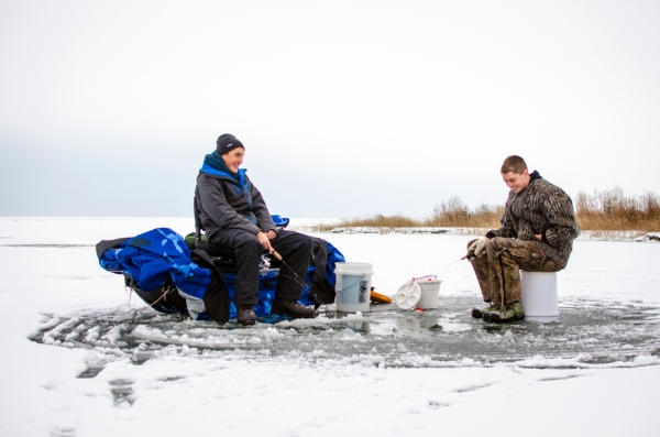 Danielle McGrew | MLive.com Ryan Weiss and Jonny Engelhardt joke as they fish for perch on the frozen Saginaw Bay in Linwood on Friday, Nov. 29. The group said it was the first time they were able to go ice fishing this season.
